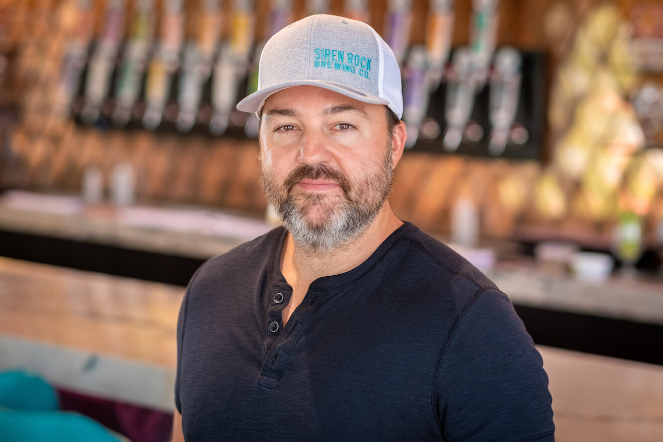 Cory Cannon sitting at a desk in a Siren Rock Brewery office